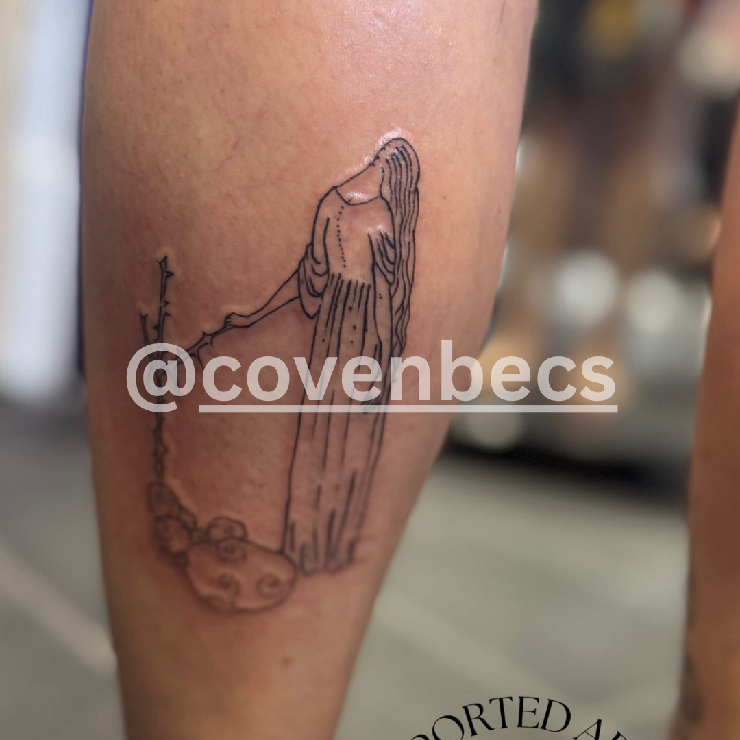 Tattoo of a fish with a chain on a person's arm, blurred background
