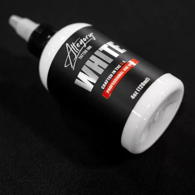 White Allegory tattoo ink bottle with black cap on a black background