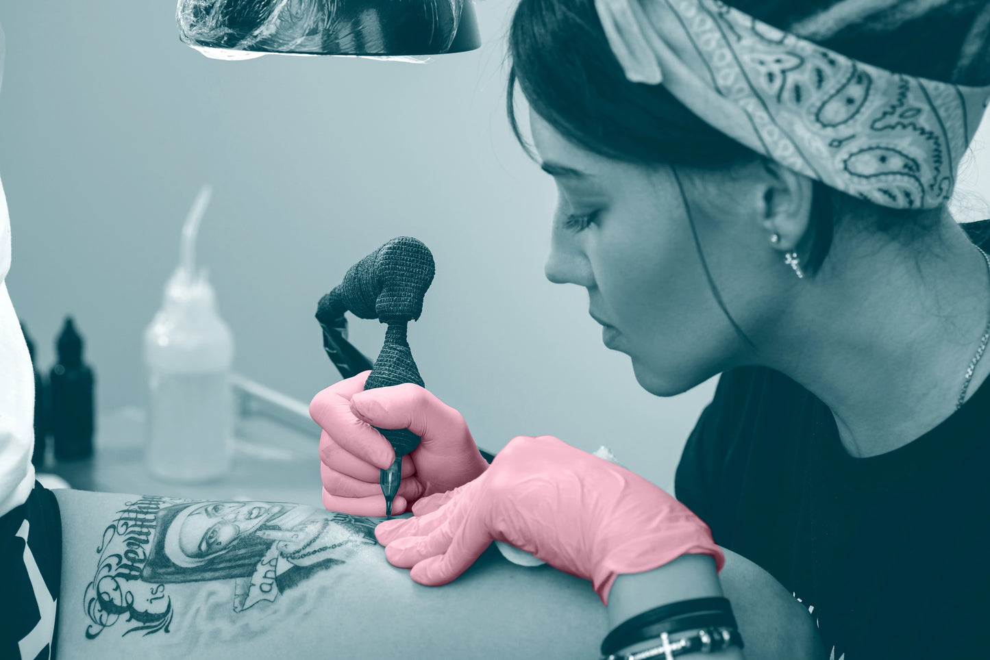 Tattoo artist wearing pink tattoo gloves