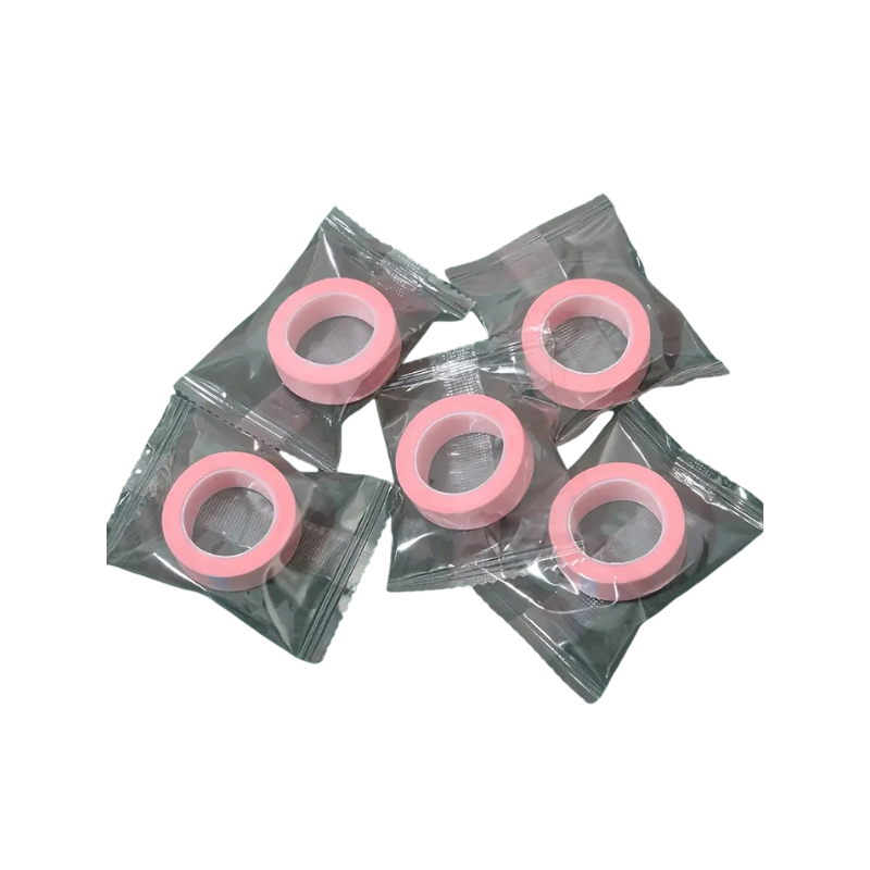 Pink microporous tape in clear plastic packaging on a white background