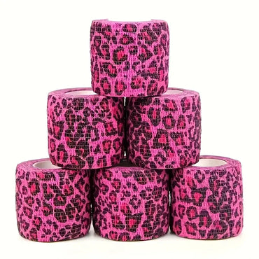 Stack of pink leopard print tattoo grip tape rolls on a white background