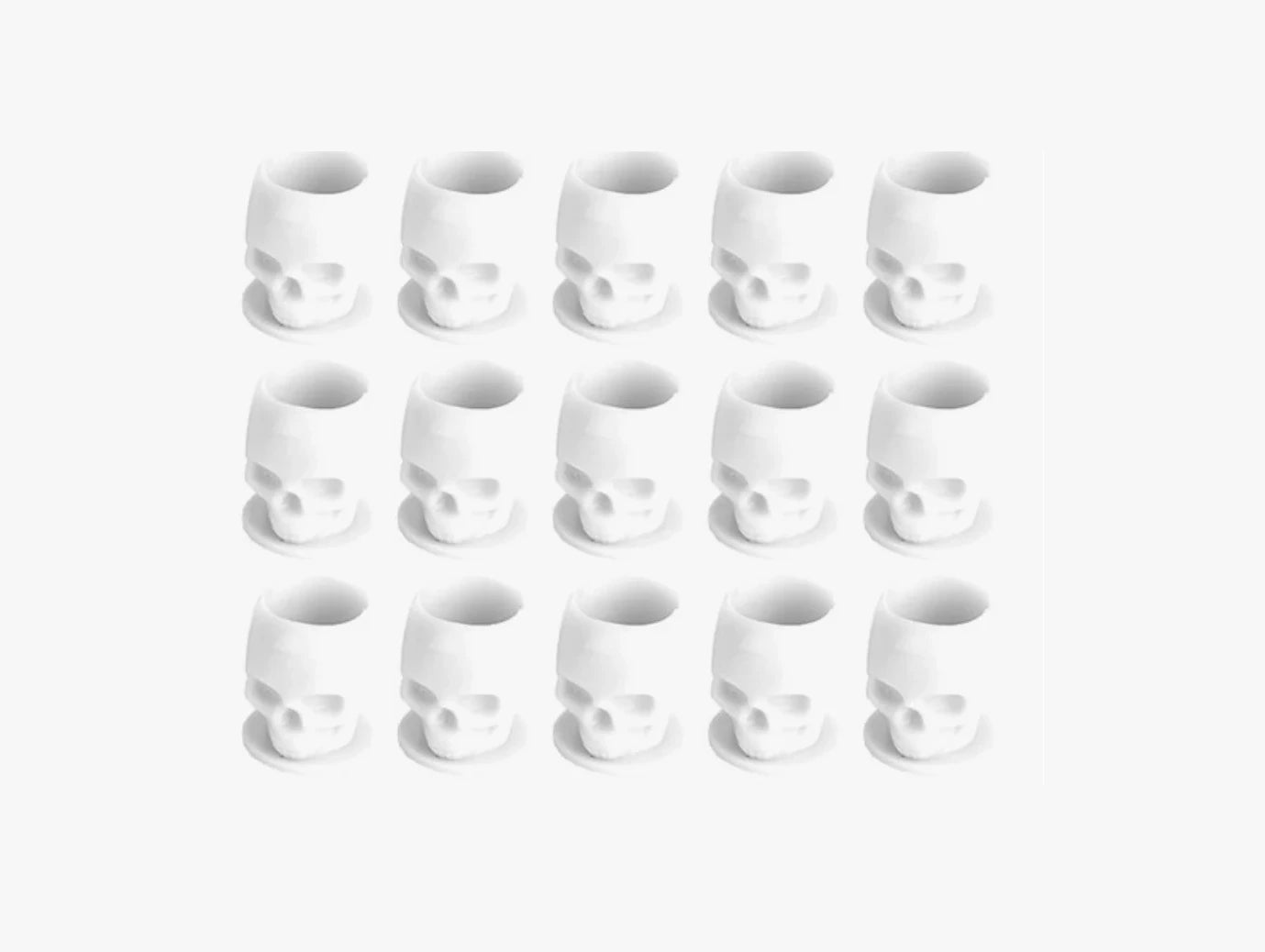 Set of white skull-shaped tattoo ink cups arranged in a grid on a white background