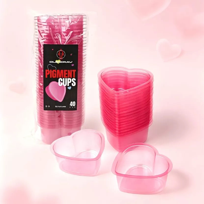 A pack Pink heart shaped tattoo rinse cups pack of 40 in pink, shown with a stack of filled cups and two empty cups in front, on a soft pink background.