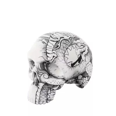 A Soft silicone tattoo practice skin for linework and shading with black and white tattoo of dragon-like scales and ornate decorative linework, shown on a plain white background.