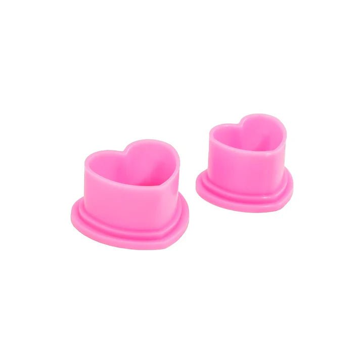 Pink heart-shaped tattoo ink caps