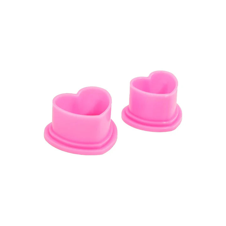 Pink heart-shaped tattoo ink caps