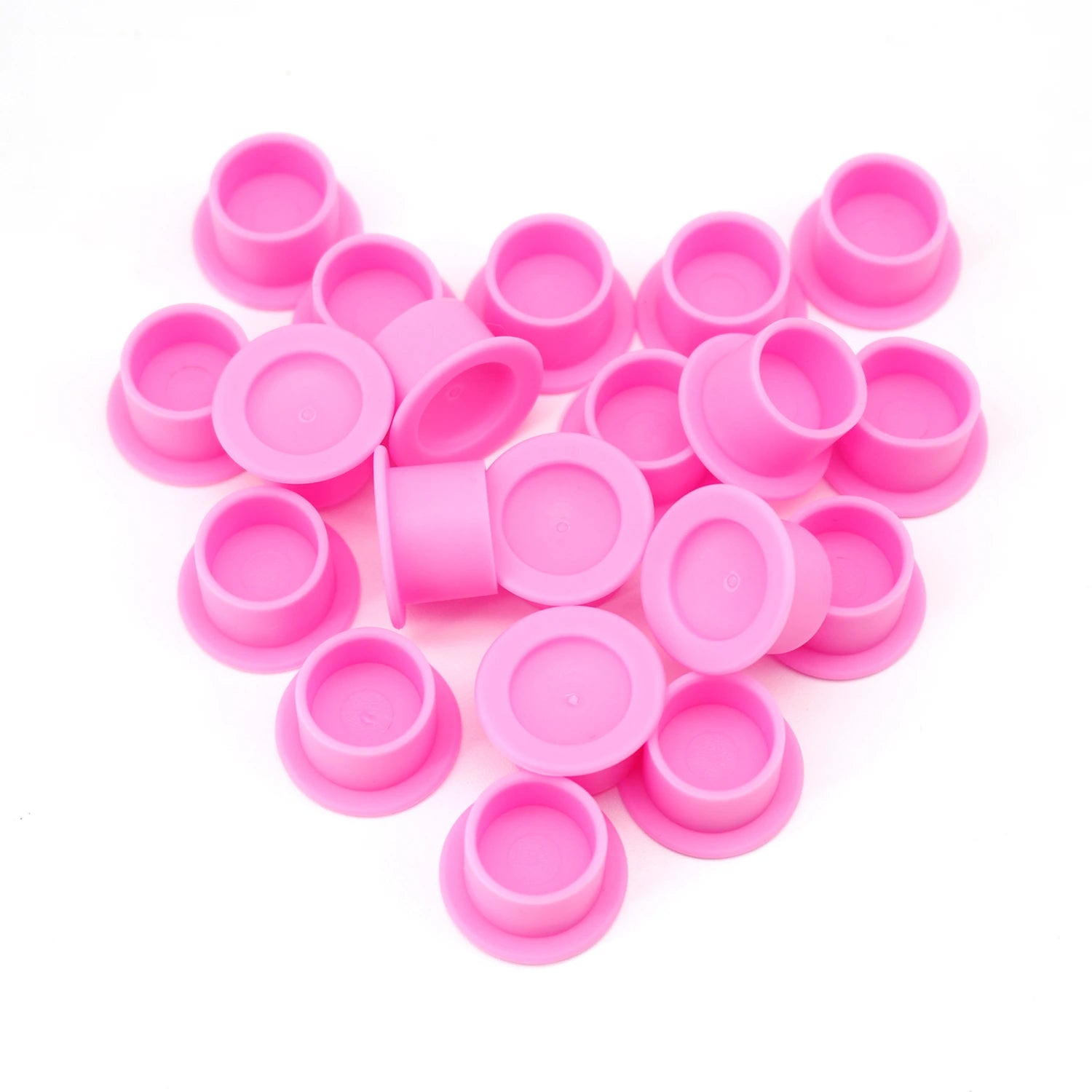 Pink Silicone Ink caps scattered on a white background