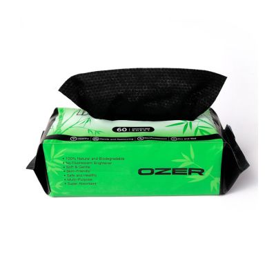 A pack of Ozer tattoo wipes with a bright green and black wrapper, with a black wipe pulled out from the top, set against a plain white background.