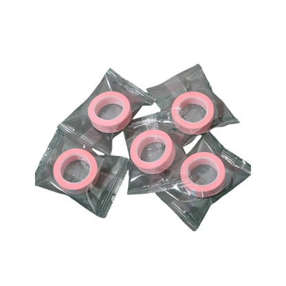 Pink microporous tape in clear plastic packaging on a white background