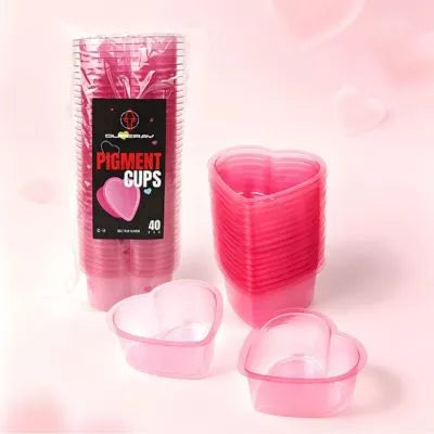 A pack Pink heart shaped tattoo rinse cups pack of 40 in pink, shown with a stack of filled cups and two empty cups in front, on a soft pink background.