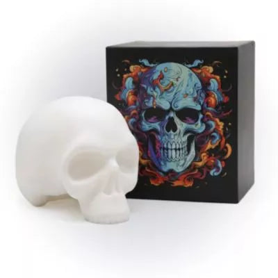 A Soft silicone skull tattoo practice skin boxed displayed in front of a black box featuring a colorful skull illustration with blue, orange, and red tones.