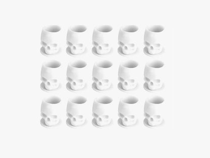 Set of white skull-shaped tattoo ink cups arranged in a grid on a white background