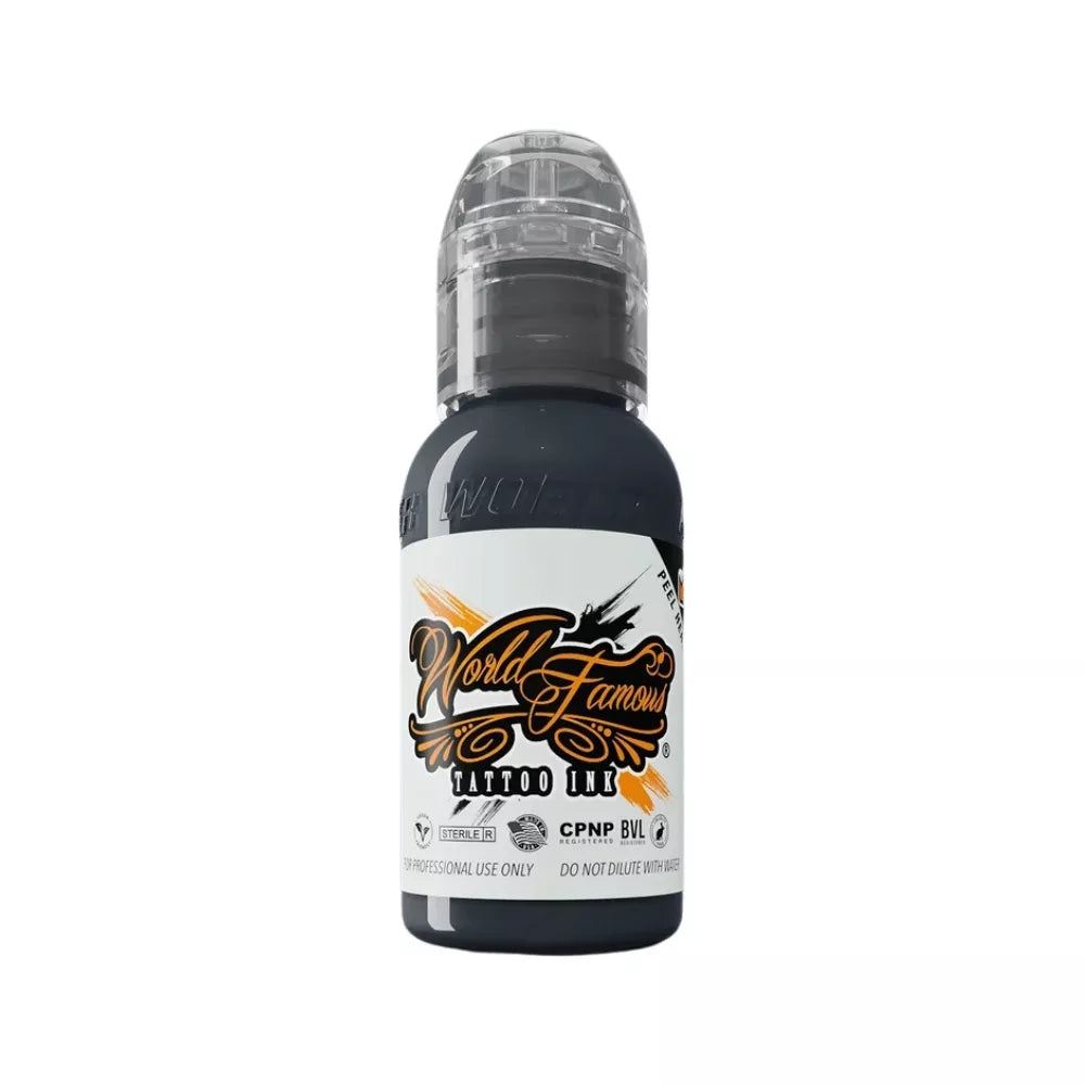 A bottle of World Famous Stonehenge Grey Tattoo Ink in black, featuring a white label with orange and black lettering, and a clear cap, shown on a plain white background.