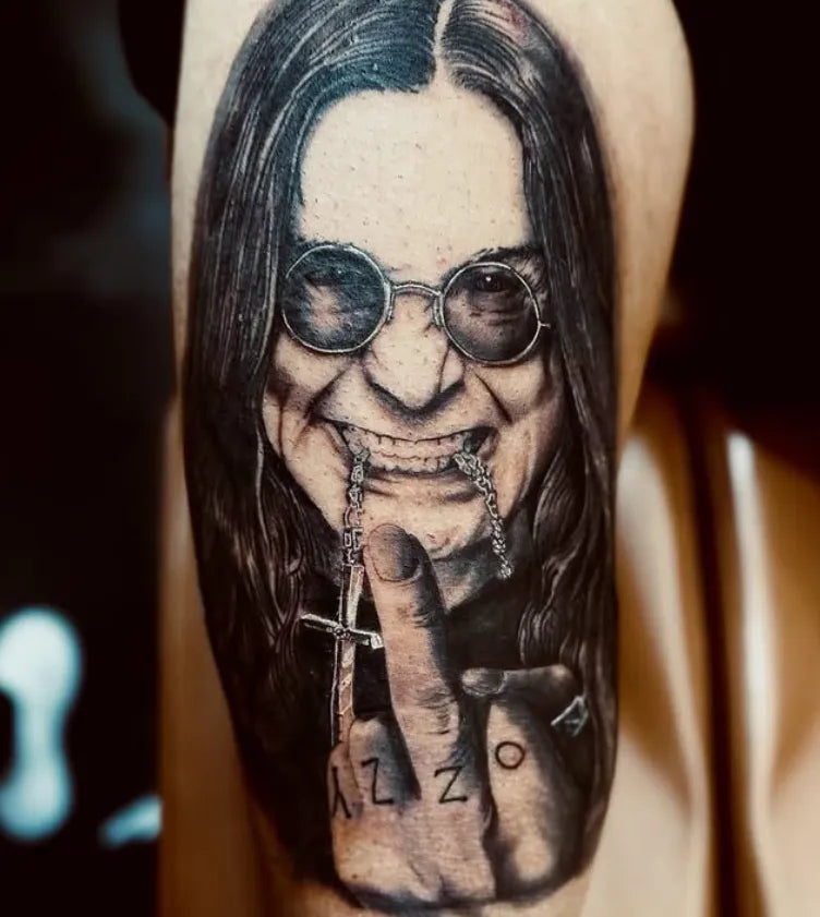 Tattoo of a person with long hair and sunglasses on a person's arm.