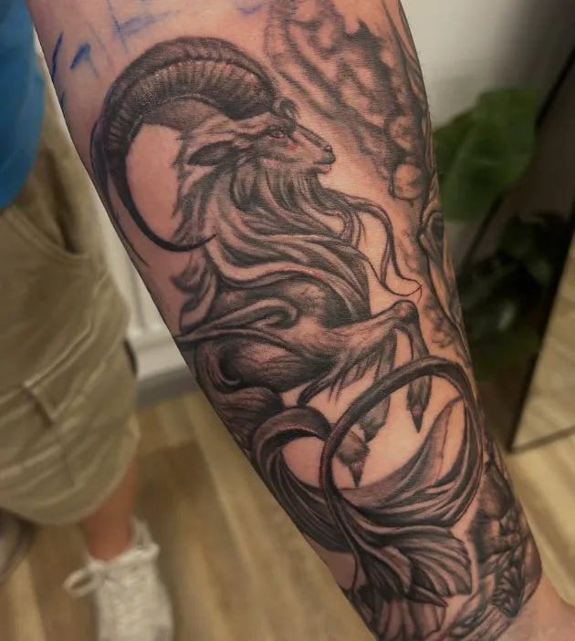 Detailed tattoo of a ram on a person's arm with a blurred background