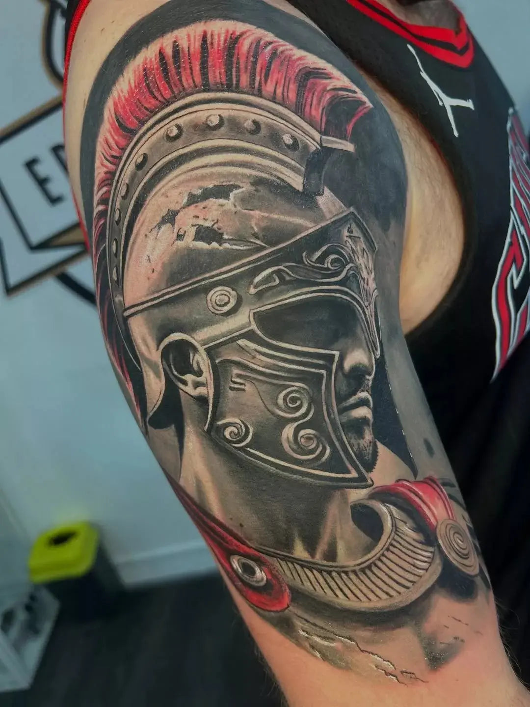 Tattoo of a warrior helmet on a person's arm with a blurred background
