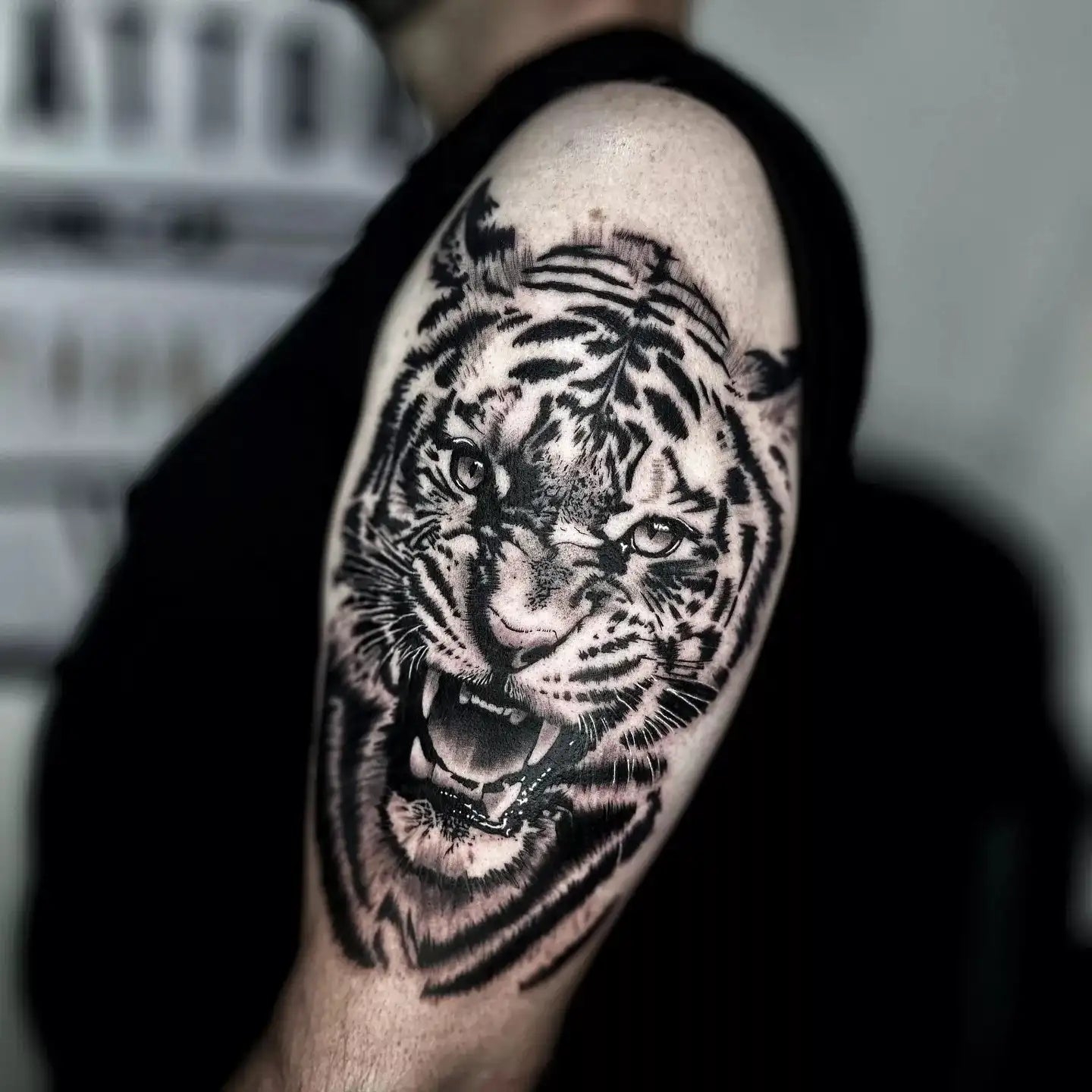 Tattoo of a tiger's face on a person's arm with a blurred background