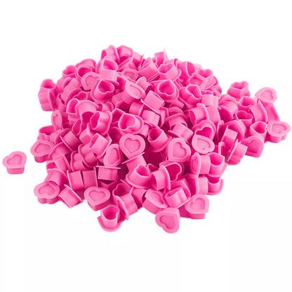 Pink heart-shaped ink caps on a white background