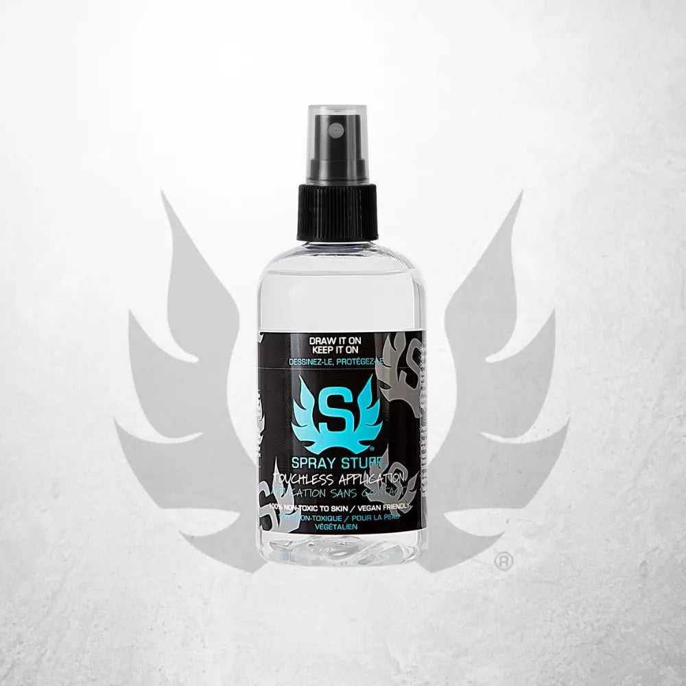 Spray Stuff 240ml freehand tattoo spray bottle with a black spray top and a black label featuring a bright blue Stencil Stuff logo and white text, centered on a light gray textured background with a faint wing-like graphic behind it.